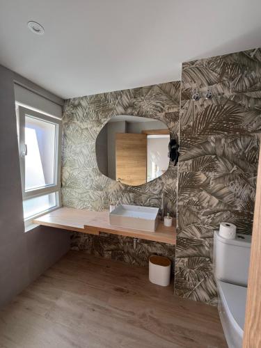 a bathroom with a sink and a mirror at Pensión el Horno REFORMADO in León