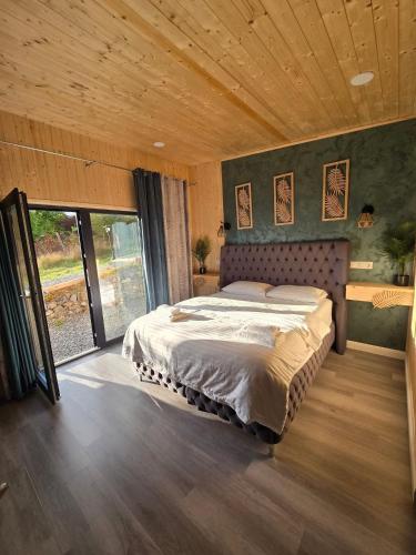 a bedroom with a large bed with a wooden ceiling at Bella Vista Bungalow in Turda