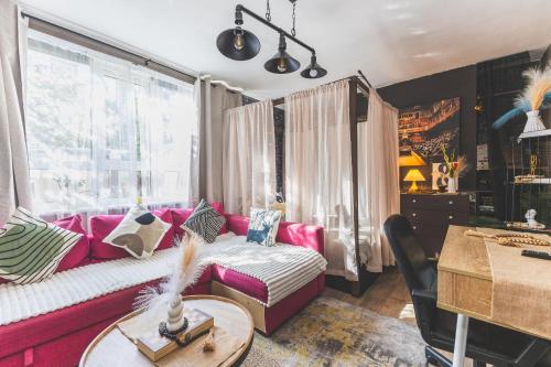 a living room with a pink couch and a table at The Serene Residence with Hot Tub, Sauna and Cinema Experience in London