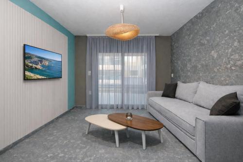 a living room with a couch and a table at MARTINI APARTMENTs MAISONETTE in Nikiti