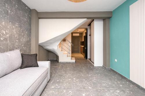a living room with a couch and a staircase at MARTINI APARTMENTs MAISONETTE in Nikiti