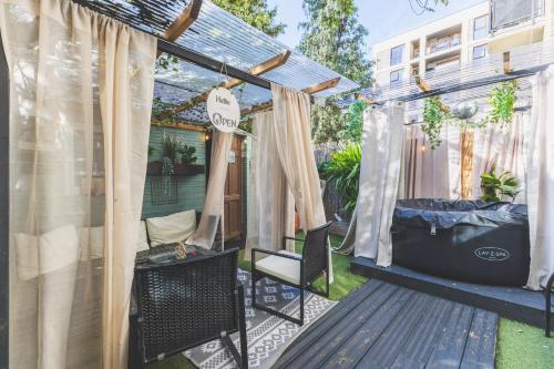 a screened in porch with a bed and curtains at The Serene Residence with Hot Tub, Sauna and Cinema Experience in London