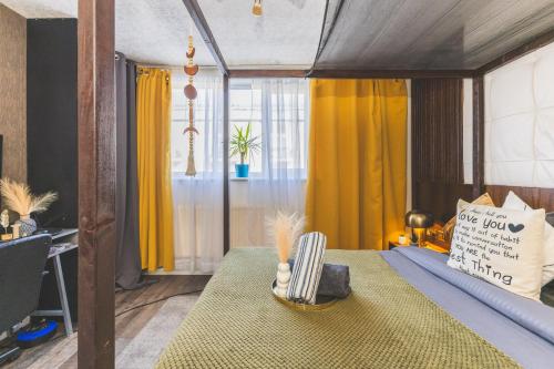 a bedroom with a canopy bed with yellow curtains at The Serene Residence with Hot Tub, Sauna and Cinema Experience in London