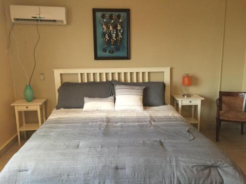 a large bed in a bedroom with two tables at The Jam Lodge in Freetown