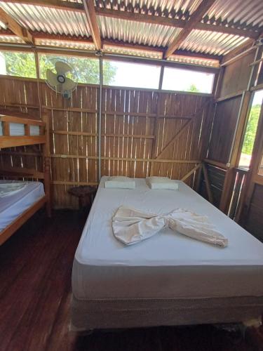 a room with a bed with a robe on it at Cabañas Dilany in Moyogalpa