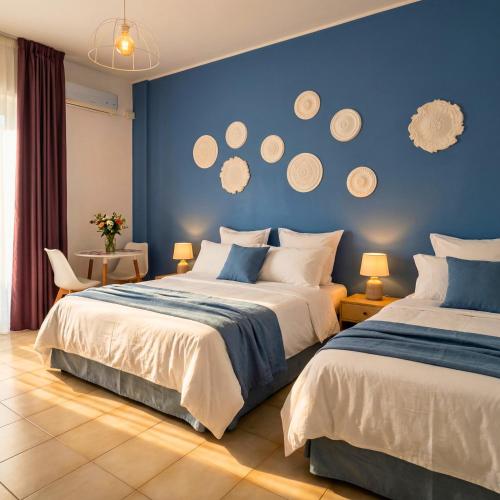a bedroom with two beds and a blue wall at Melo Accommodations in Bari