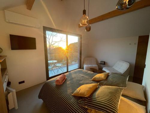 a bedroom with a bed and a large window at STUNNING VIEW, chambre en forêt proche BORDEAUX in Bouliac