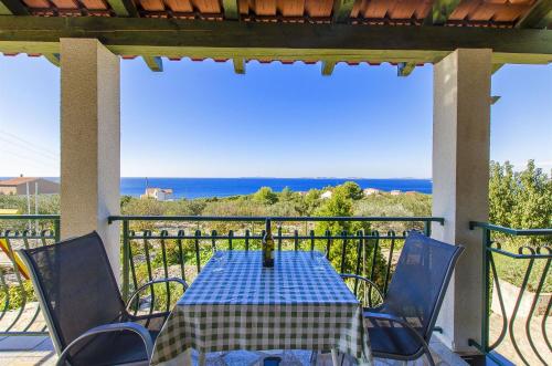 a table and chairs on a balcony with the ocean at House Marija in Primošten