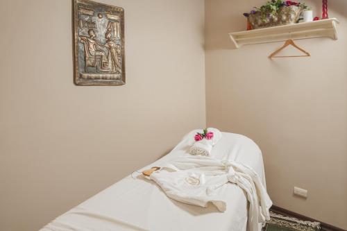 a room with a bed with white sheets and a painting at Marinaterra Hotel & Spa in San Carlos