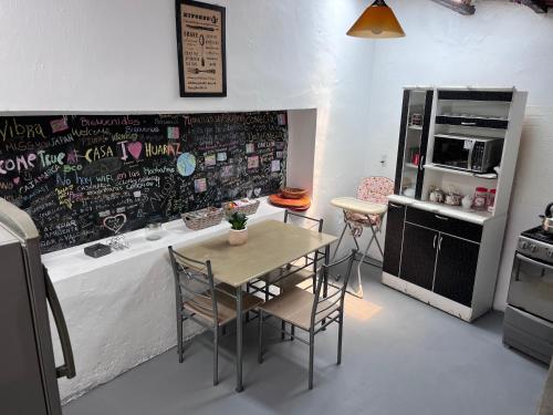 a kitchen with a table and chairs and a chalkboard wall at Casa I Love Huaraz in Huaraz