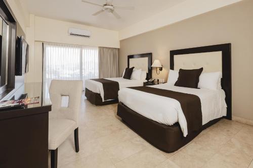 a hotel room with two beds and a television at Marinaterra Hotel & Spa in San Carlos