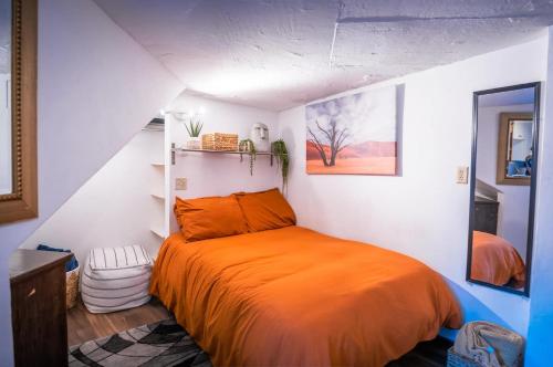 a bedroom with a bed with an orange blanket at Stylish Apartment Upscale Chapultepec District in Tijuana