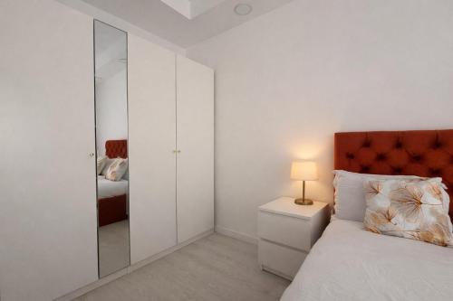 a white bedroom with a bed and a mirror at Damon Suite #NorthBucharest in Tunari