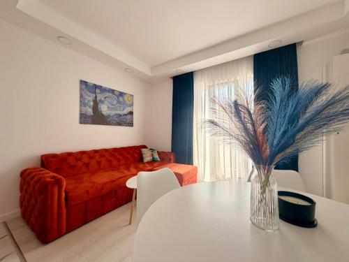a living room with a red couch and a table at Damon Suite #NorthBucharest in Tunari