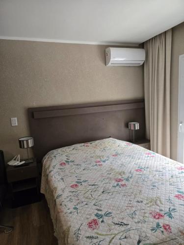 a bedroom with a bed with a floral bedspread at Casa del Parque estudio 4 pax in Necochea