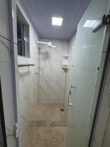 a bathroom with a shower with a glass door at Pousada JV Para-tí in Paraty