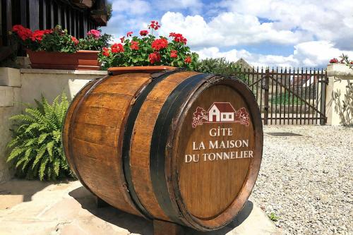 a large wooden barrel with a sign on it at Gite la Maison du Tonnelier in Comblanchien