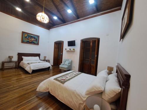 a bedroom with two beds and a chair in it at Rossa Mia Hotel Boutique in Quito