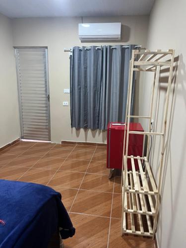 a room with a bed and a ladder and curtains at Flat Yellowtuna in Fernando de Noronha