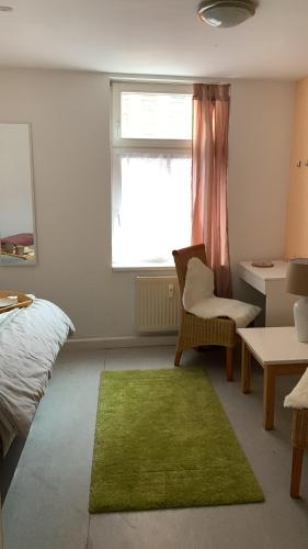 ein Schlafzimmer mit einem grünen Teppich, einem Bett und einem Fenster in der Unterkunft Ellerbach WG Komfortables Privatzimmer in Bad Kreuznach