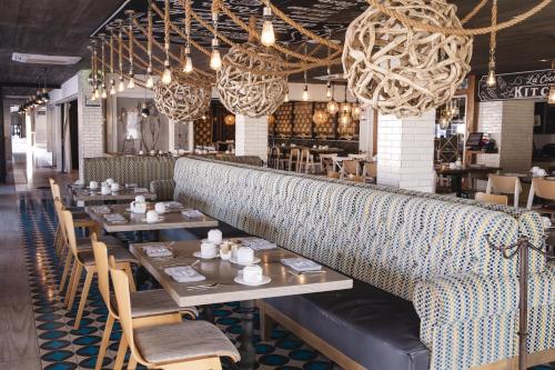 a dining room with tables and chairs and chandeliers at Marinaterra Hotel & Spa in San Carlos
