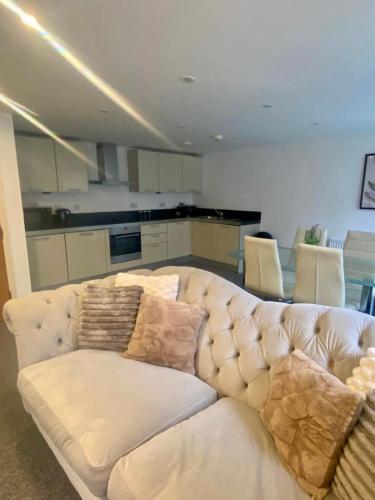 a white couch in a room with a kitchen at Central Southsea Duplex Apartment 2BR Parking Dogs in Portsmouth