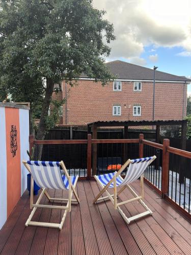 two chairs sitting on the deck of a house at Zozy Gladstone in London