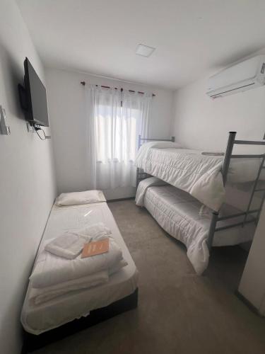 a bedroom with two bunk beds and a television at DOCTA Residencia in Córdoba