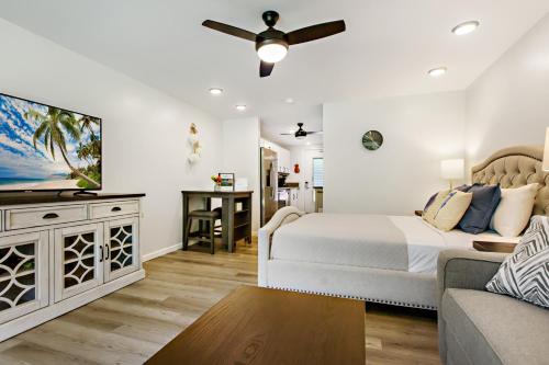 a bedroom with a bed and a flat screen tv at Napili Puamala 128 in Kahana