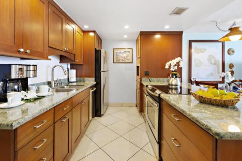 a kitchen with wooden cabinets and granite counter tops at Kahana Reef 318 in Kahana