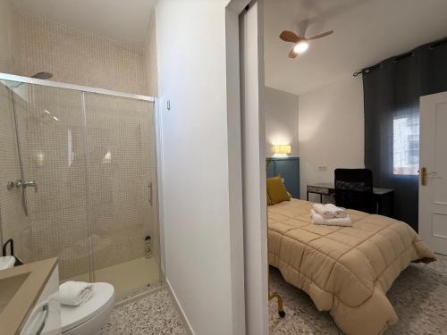 a bedroom with a bed and a bathroom with a shower at Casita Machado in Úbeda