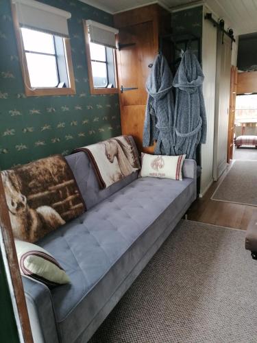 a couch in a room with green walls at Theddlethorpe Horsebox Glamping in Theddlethorpe Saint Helen