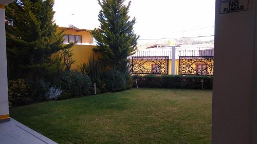 a yard with a fence and two trees at HOTEL REAL DEL MONTE WOODs in Mineral del Monte