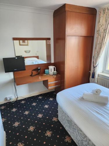 a hotel room with a bed and a mirror at The Limes Hotel in Market Rasen