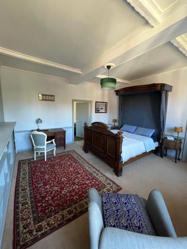 a bedroom with a bed and a couch in a room at Maison de caractère au calme en pleine campagne in Rollancourt