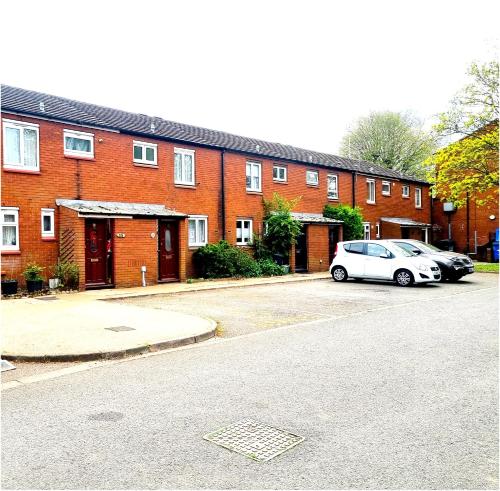 a white car parked in front of a brick building at 3bed 2bath House-Free Parking-Fast WiFi-Garden-Entire Home-2mins from Train Station-Sleeps 6 in London