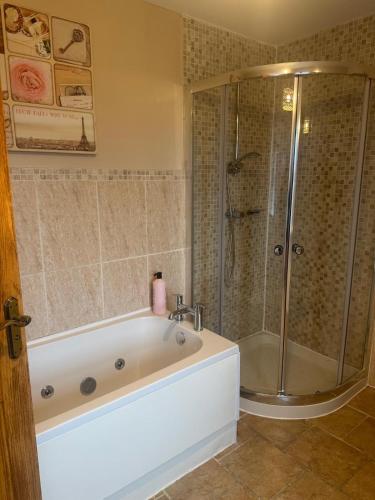 a bathroom with a tub and a shower at Dessie's in Magherasaul
