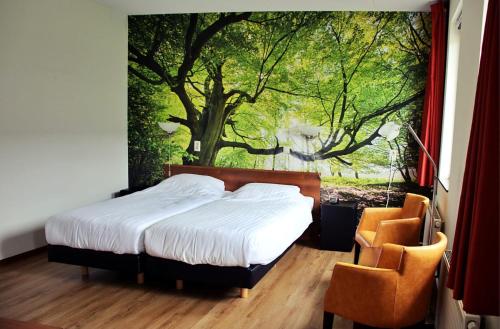a bedroom with a bed with a large painting on the wall at Horsetellerie Rheezerveen in Hardenberg