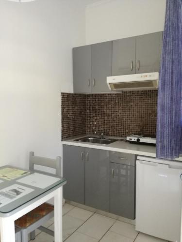 a kitchen with gray cabinets and a sink at Kanali Studios in Parga