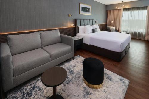 a hotel room with a bed and a couch at Crowne Plaza Villahermosa by IHG in Villahermosa