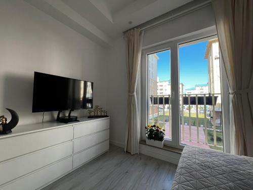 a bedroom with a flat screen tv and a large window at Kream Suite #Cosmopolis #Bucharest in Ştefăneştii de Sus