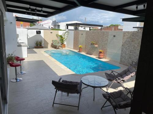 a swimming pool on a patio with chairs and a table at Casa de Descanso Lili in Ricaurte