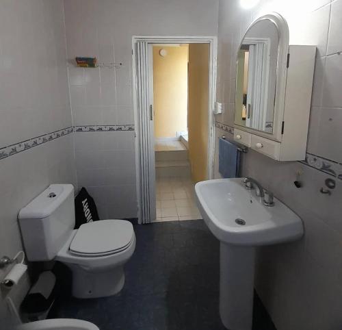 a white bathroom with a toilet and a sink at Temporario Elisa in Santa Fe