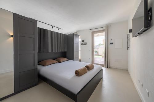 a bedroom with a large bed with two pillows on it at Relax Stay - Camere e Appartamenti con Giardino in Quartu Sant'Elena