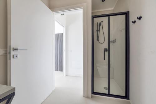 a bathroom with a shower with a glass door at Relax Stay - Camere e Appartamenti con Giardino in Quartu Sant'Elena