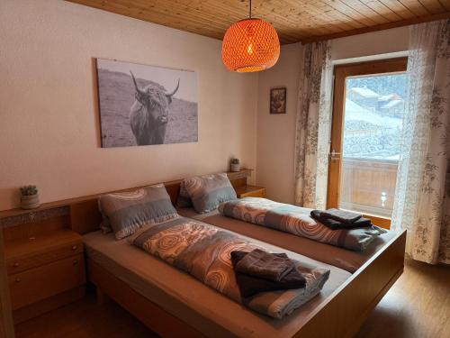 a bedroom with two beds and a picture of a bull at Haus Sauberbach in Jerzens