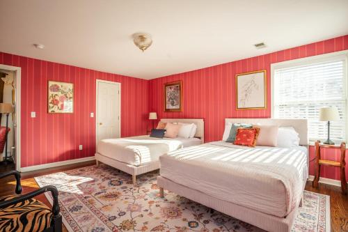 two beds in a room with red walls at Eden at Blue Lane in Olathe