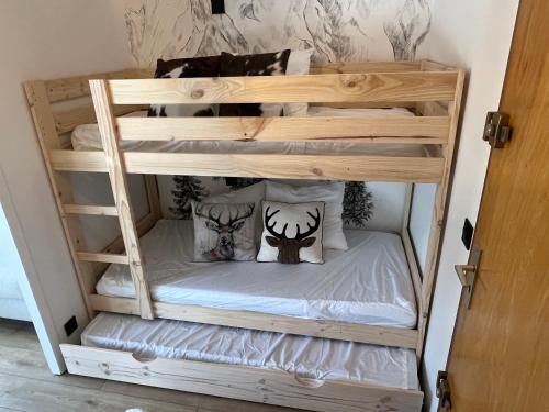 a wooden bunk bed with pillows on it at Studio Carroz d'Arâches 4 pers in Arâches-la-Frasse