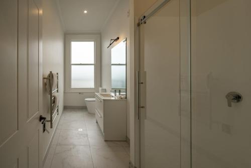 a bathroom with a shower and a toilet and a window at The Empire Hotel in Timaru