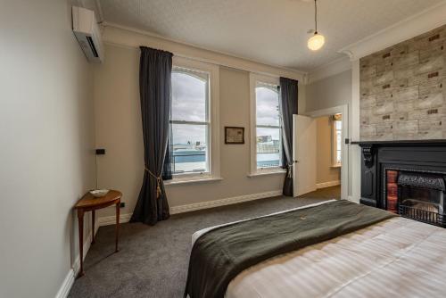 a bedroom with a bed and a fireplace at The Empire Hotel in Timaru